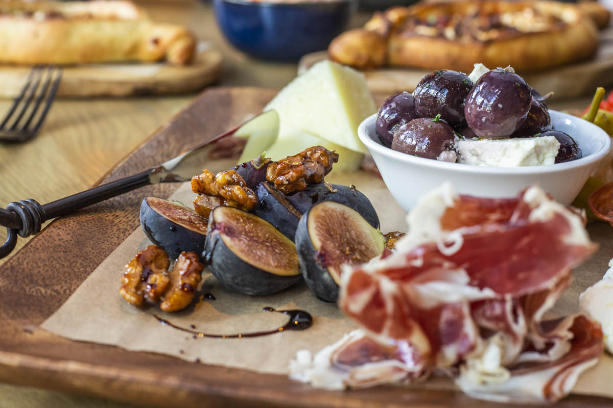 Close-up of charcuterie items including figs, cheese and candied walnuts.