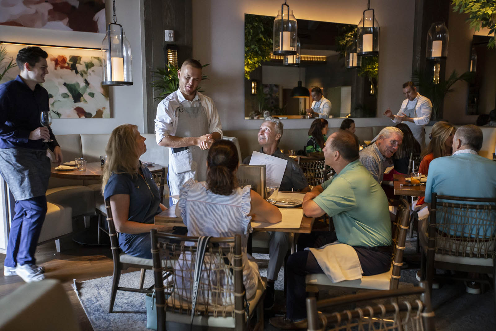 Server taking order at group table at Del Mar Naples restaurant in Florida.